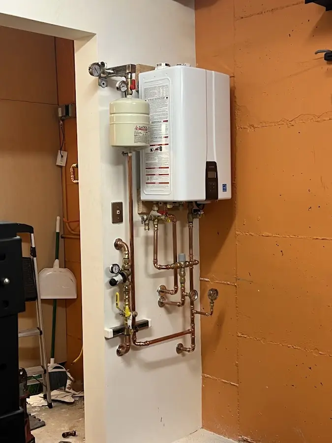 Plumbing technician inspecting water heater connections in Bend